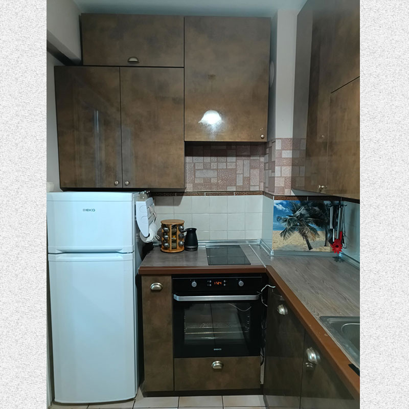 picture of a kitchen. We see cabinets with built-in oven and stove and refrigerator