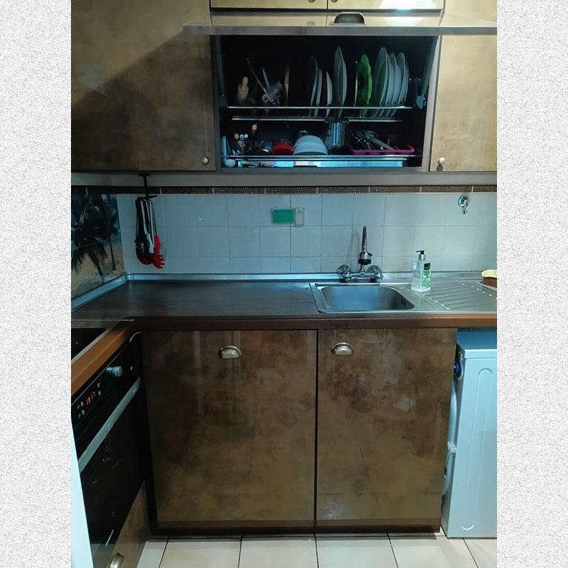 picture of a kitchen. We see cabinets with built-in oven and stove and sink